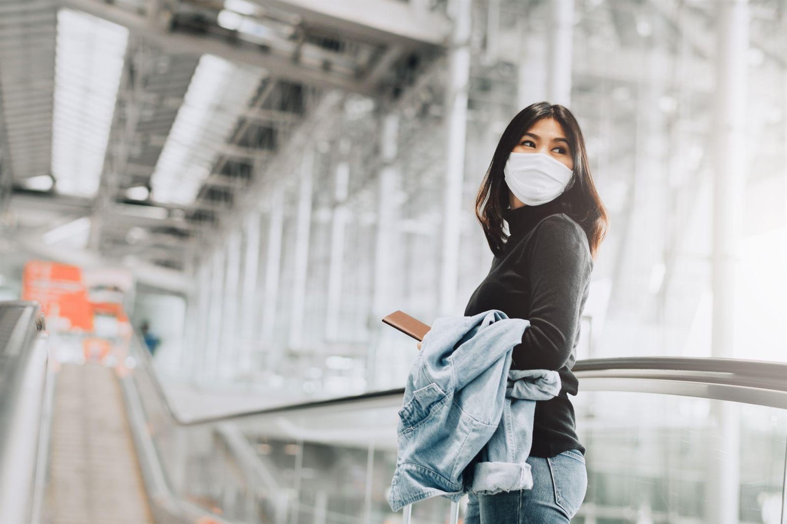 A traveller with a passport in an airport terminal