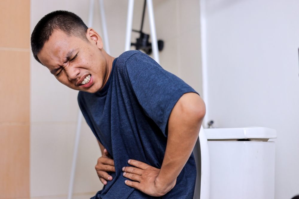 A man holding his stomach in discomfort
